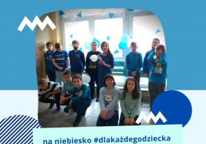 Grupa uczniów stoi w niebieskich strojach. W tle widać korytarz szkolny ozdobiony niebieskimi girlandami i balonami. Na zdjęciu napis "na niebiesko #dlakażdegodziecka".